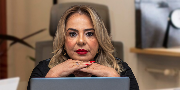 Valéria Masson, na frente do computador, com olhar determinado