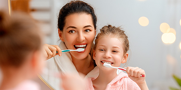 Mãe e filha escovando dente